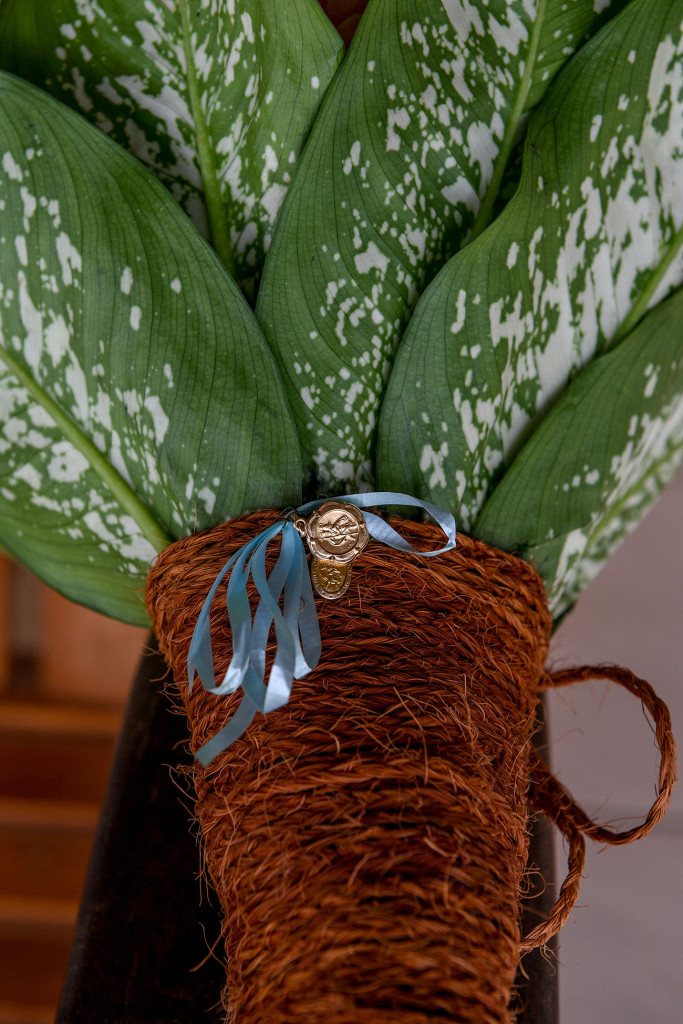 Traditional family medallion (something blue) draped on green and white ferns