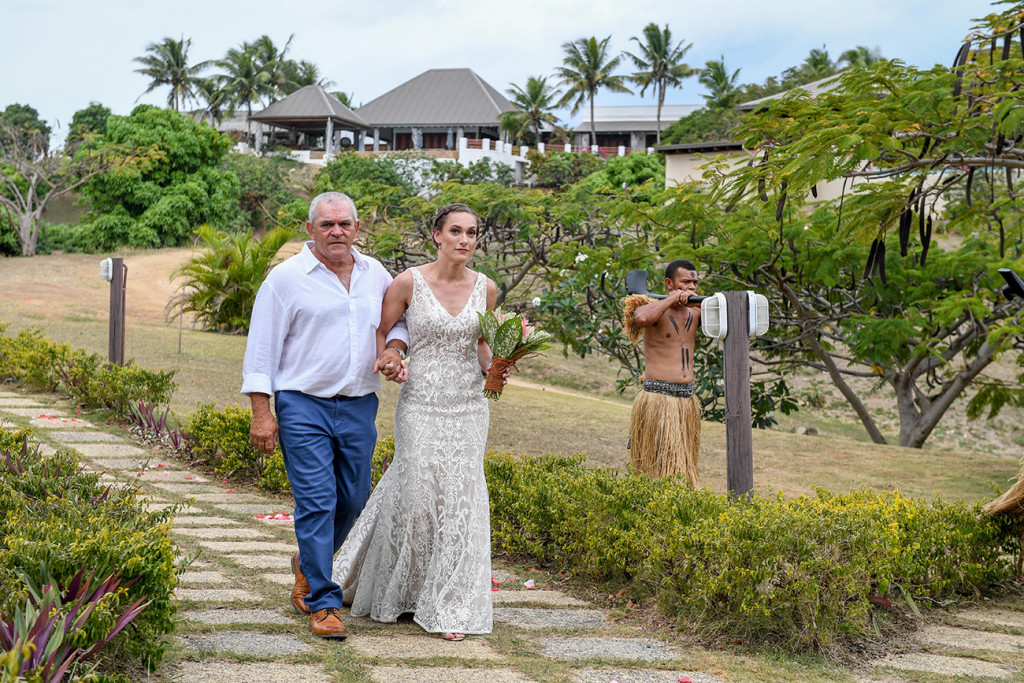 The gorgeous bride walks down the aisle with her father