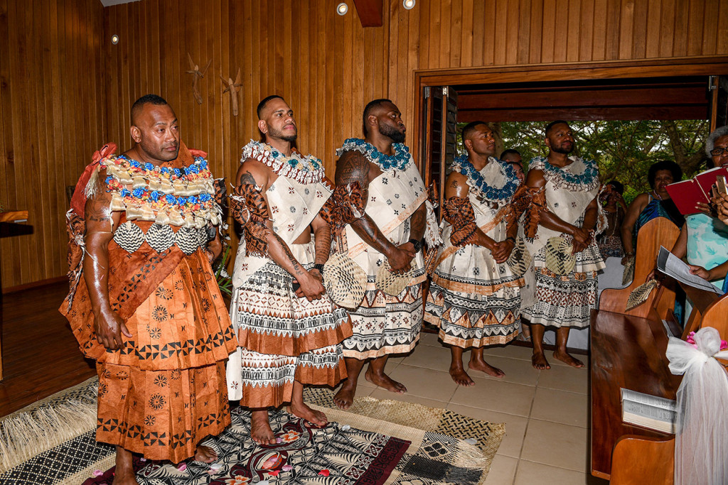 Groom and groomsmen dressed in traditional Fiji masi wait at the altar