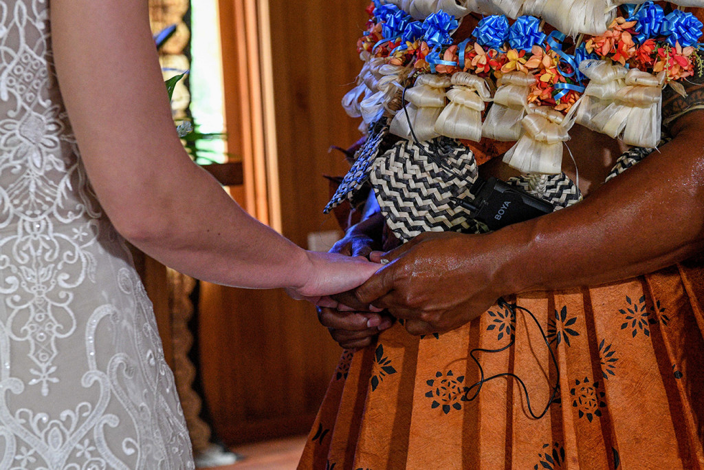 Closeup of groom and bride holding hands at the altar
