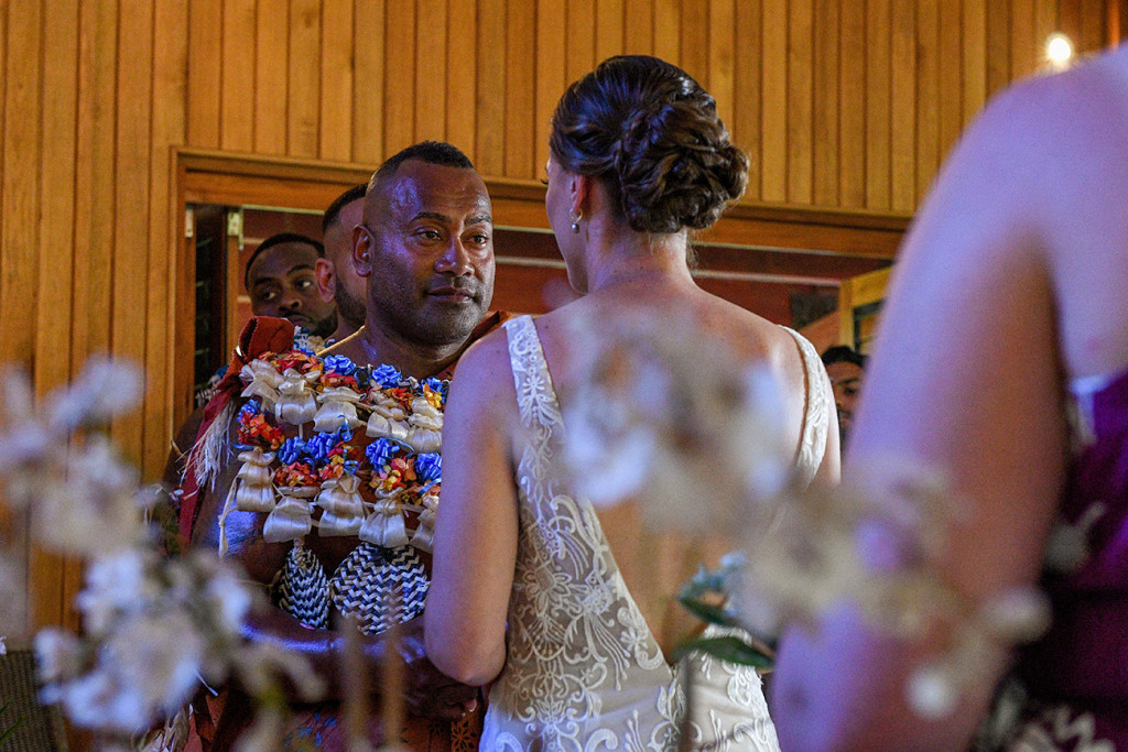An emotional Fiji groom watches as his bride says her vows