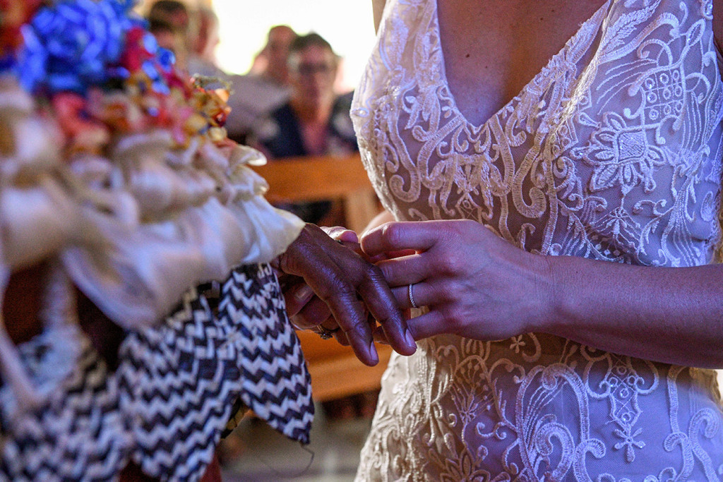Closeup of the bride slipping the silver wedding ring onto her groom