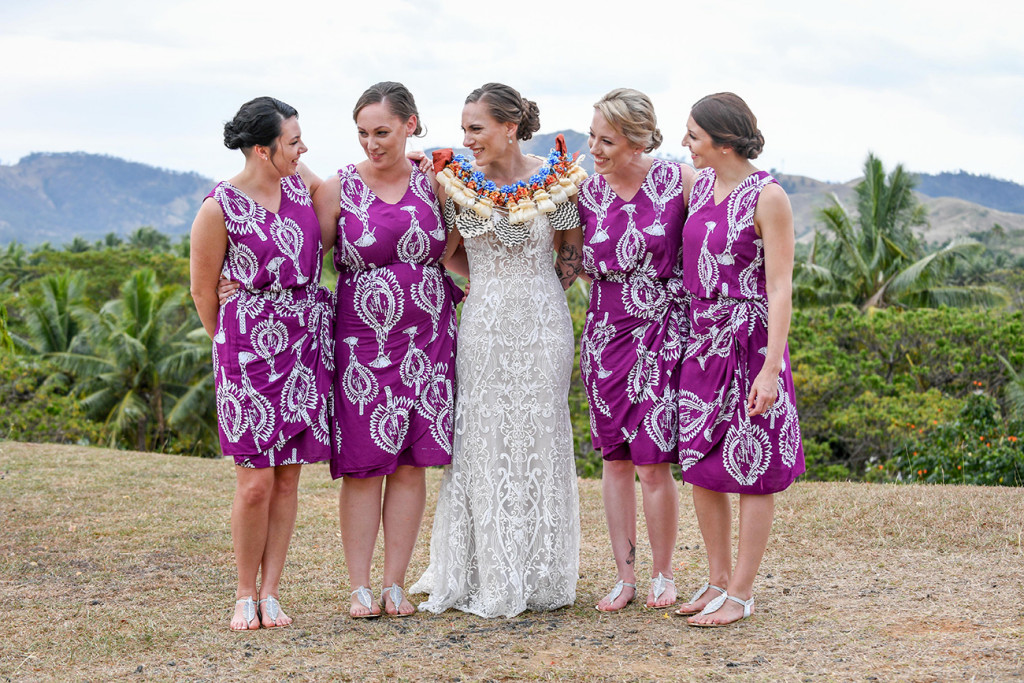 The bride and her bridesmaids chat over a photo