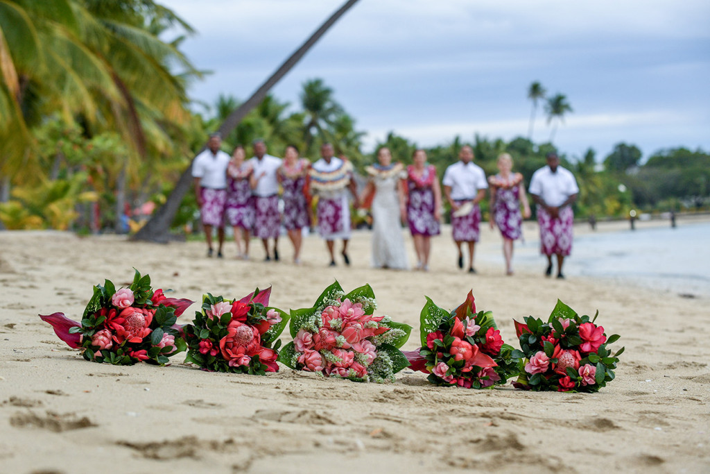 Closeup of red gingers on the shore with blurred background of bridal party in the distance