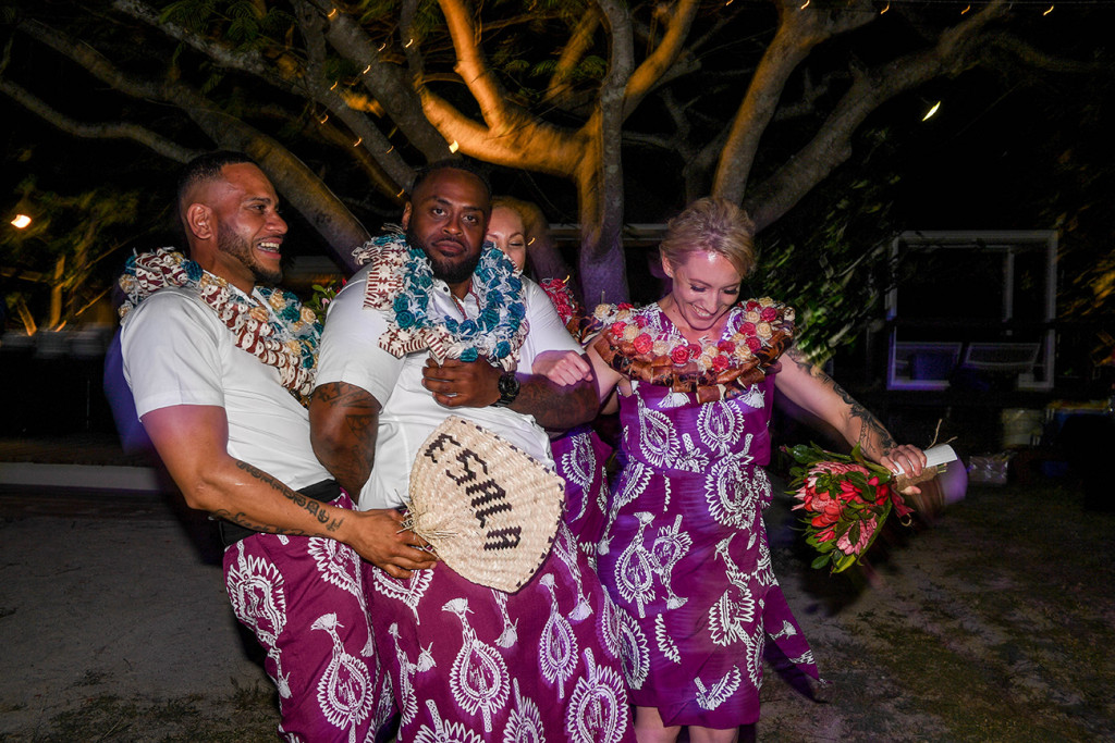 The bridal party in traditional Fiji skirts dance with the bride's customised fan