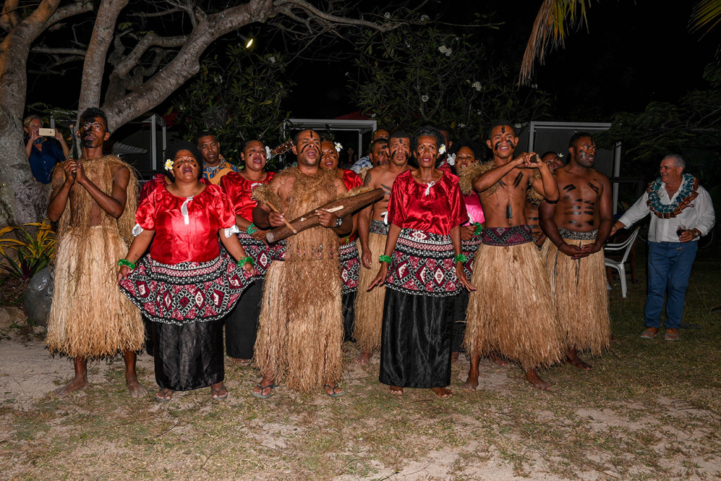 Traditional wedding Fiji meke (dance) performed under fairy lights on the beach