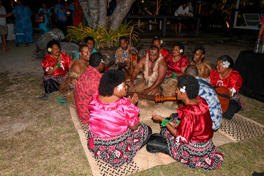 Sitting on a handwoven kivu (mat) as they perform a Fiji meke