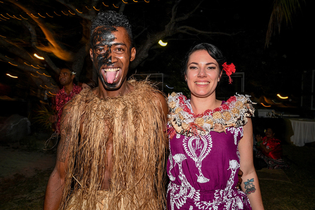 A face painted Fiji dance performer poses with one of the bridesmaids