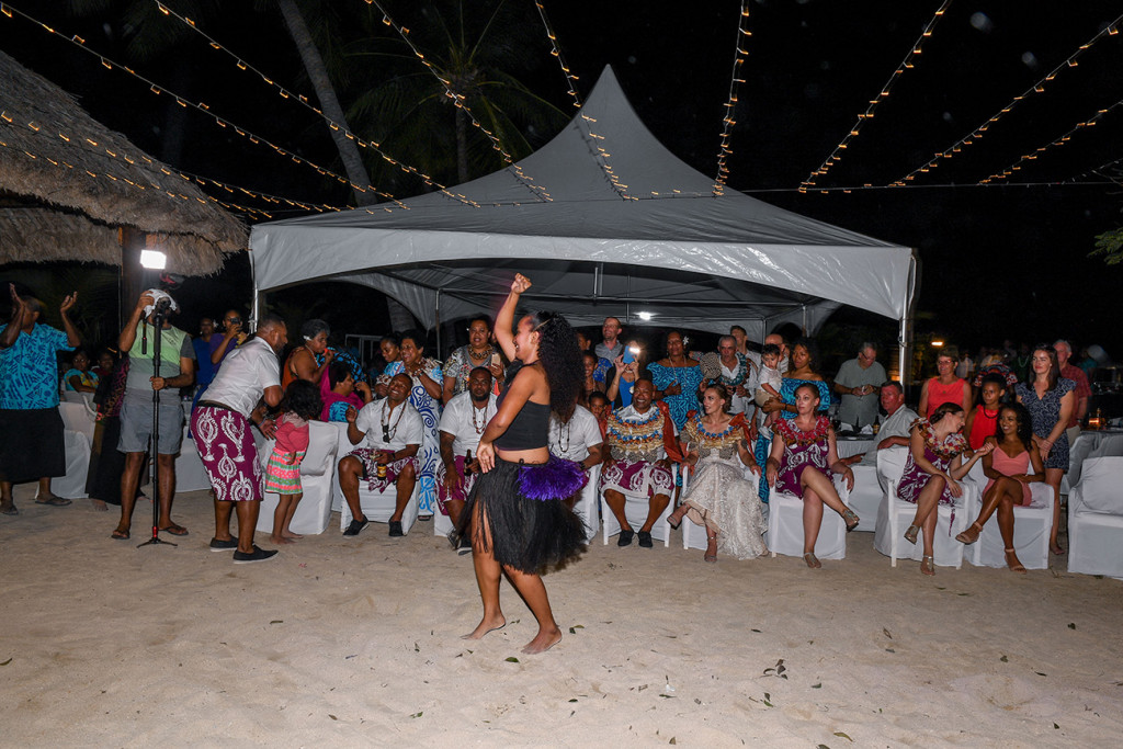 A Fiji dancer wearing black sisal skirt entertains the wedding guests