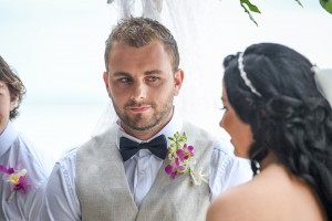 The groom watches keenly as the bride says her vows