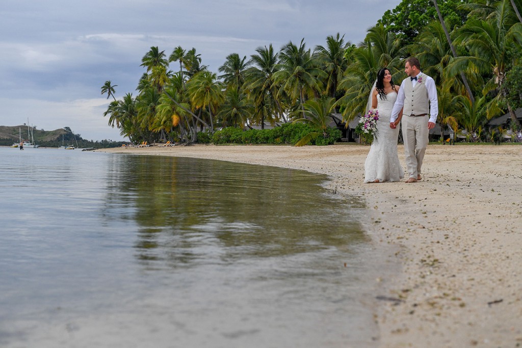 The newly weds stroll along the Plantation Island Resort beach