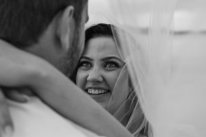 The bride has a gleeful smile under the veil