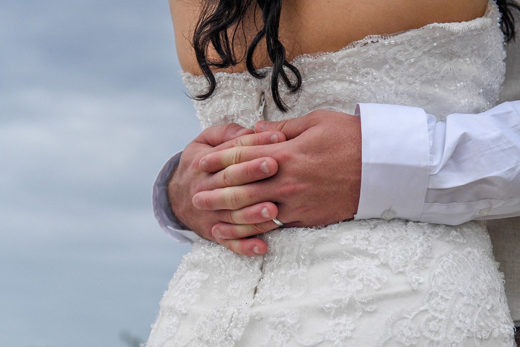 Groom's hands behind bride's back