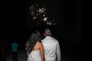 The newly weds watch fireworks in the sky
