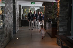The daughter of the couple runs towards the groomsmen