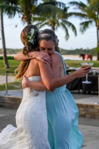 A bridesmaid emotionally hugs a bride