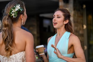 A bridesmaid animatedly chats up the bride