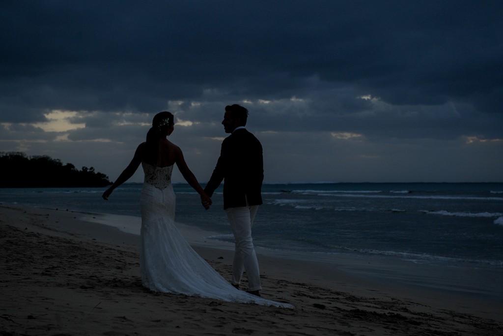 The newly weds stroll on the beach after dark