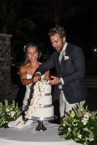 The couple cut their three tier, white, wedding cake