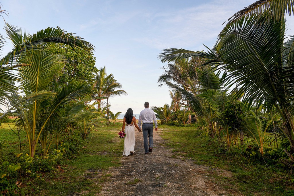 The couple strolls through palm trees