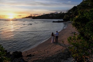 The newly weds stroll on the lonely Savasi beach at sunset