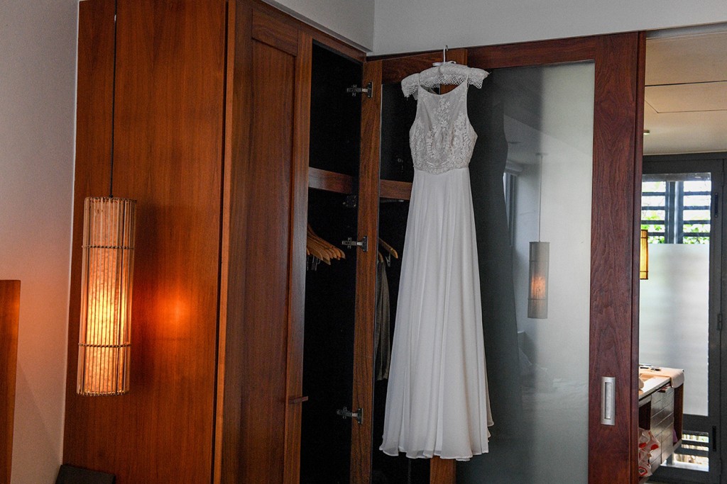 The stunning white lace sleeveless wedding gown hangs from the closet