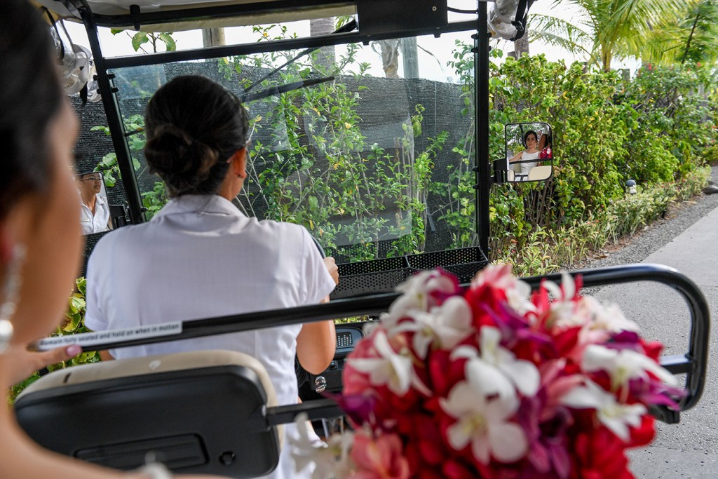 The bride is driven to the venue on a small golf cart