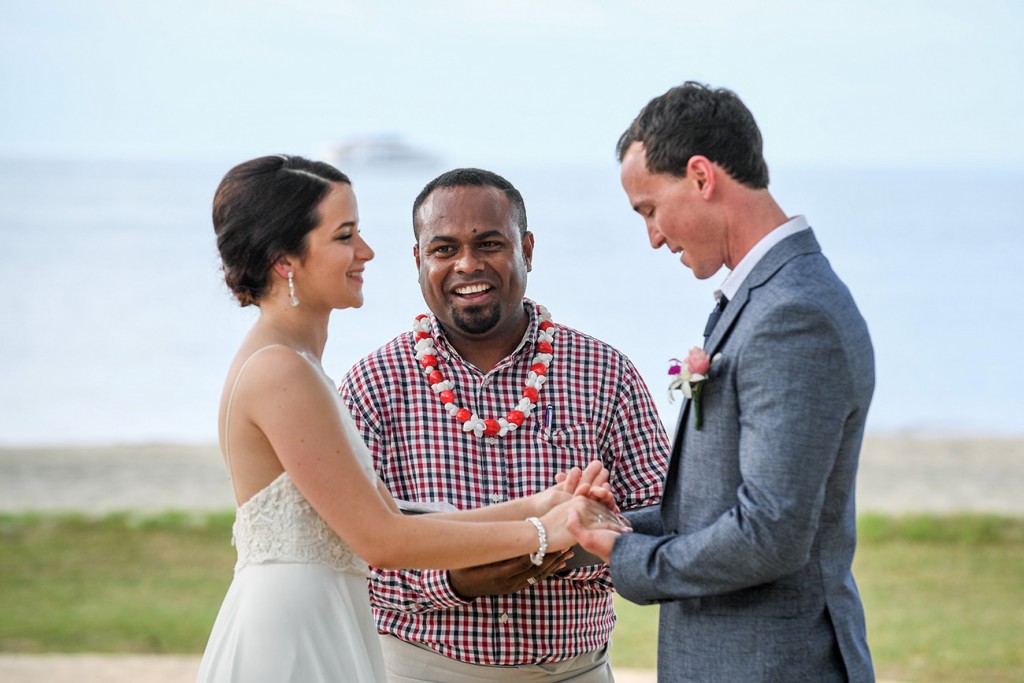 The emotional groom holds his bride's hands while saying his vows