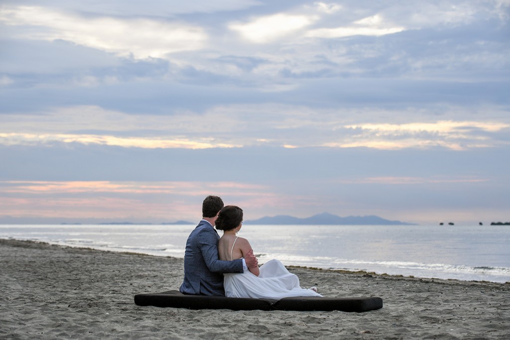 The stunning couple watches the Fiji sun set behind grey skies