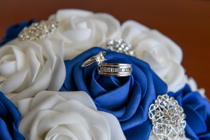 Diamond and silver rings rested on a blue rose