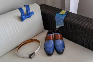The groom's checkered blue bow tie and leather shoes laid out