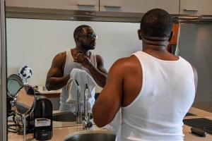 A reflection of the groom shaving as he preps for his wedding