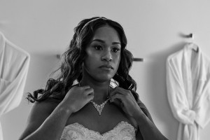 A monochrome photo of the bride admiring her necklace