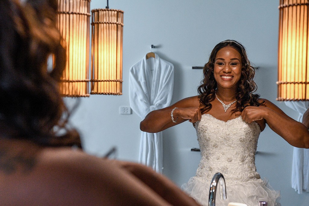 The bride smiles as she admires her reflection in the mirror