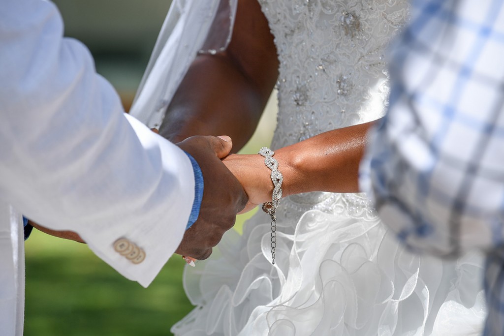 The bride and groom hold hands as they exchange vows