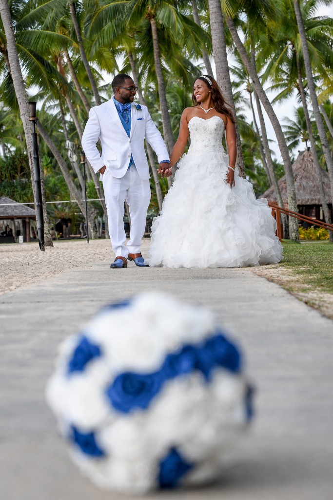 The bride smile behind their blue and white rose bouquet