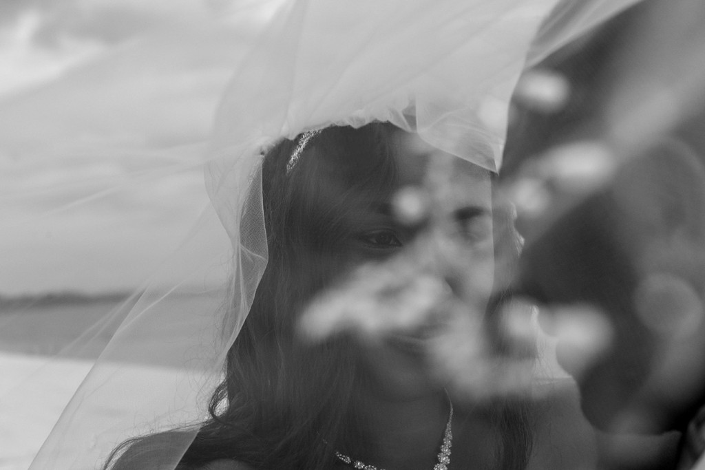 A stunning bokeh photo of the bride under the veil