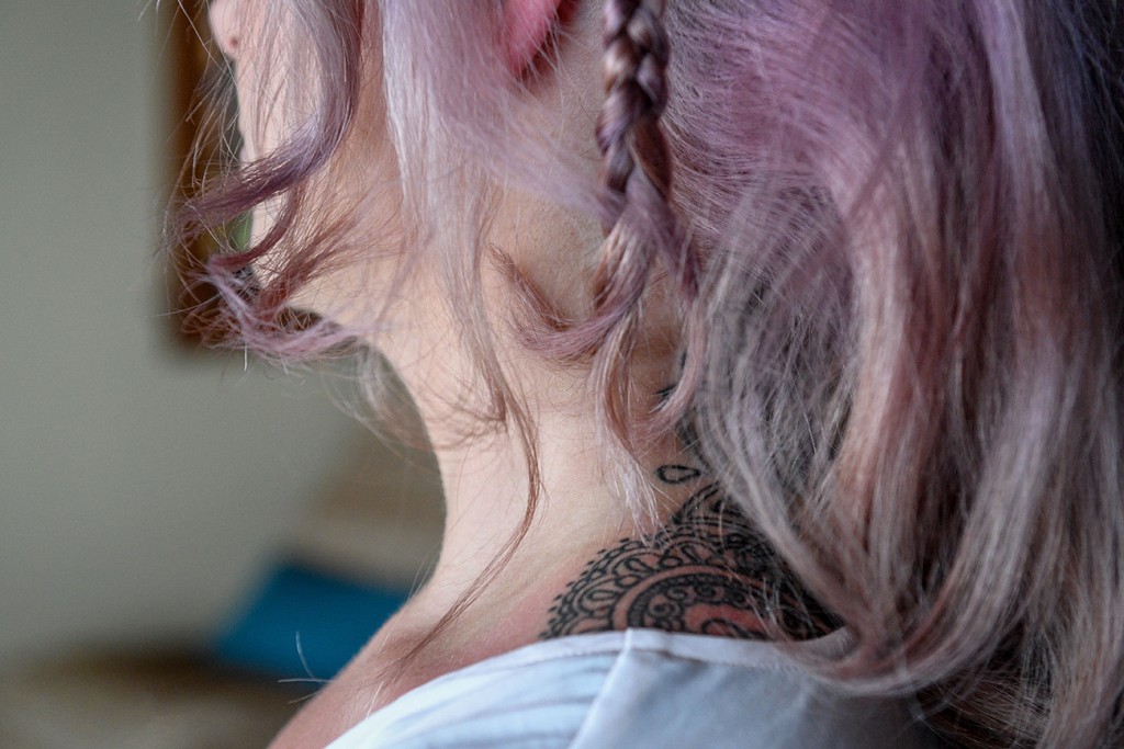 A simple braid is plaited on the bride's purple hair