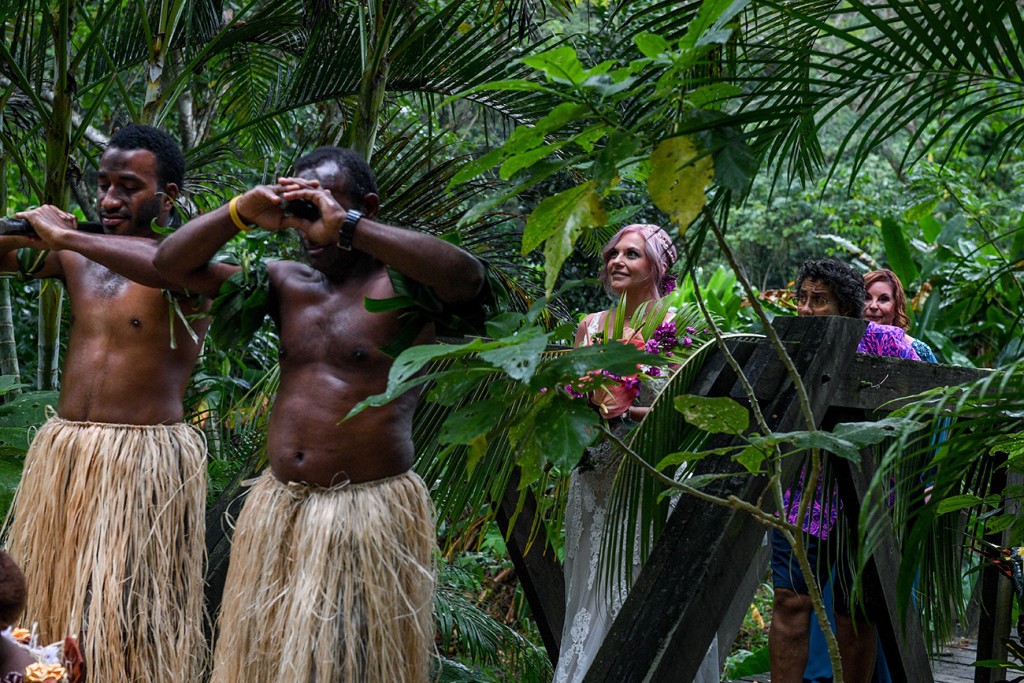 The bride is led into the ceremony venue by traditional Fiji warriors