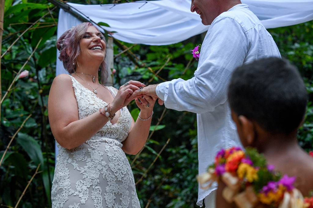 The bride slips the ring onto her groom's finger