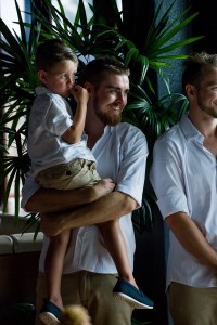The groom carries his son while standing at the altar