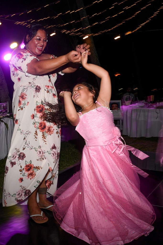 A flowergirl dances with her aunty at the wedding reception