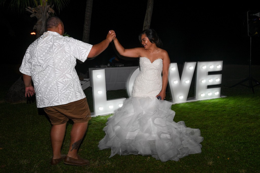 The bride and groom dance against a post sign love