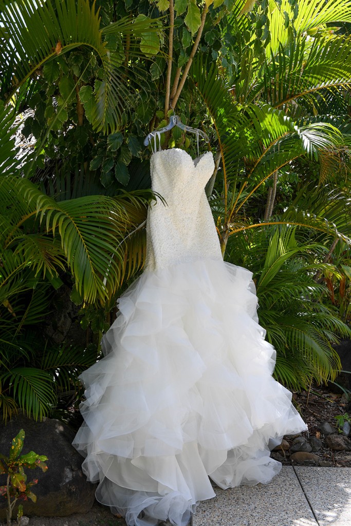 The madrid wedding gown by Sweetheart bridals hanging against palm trees