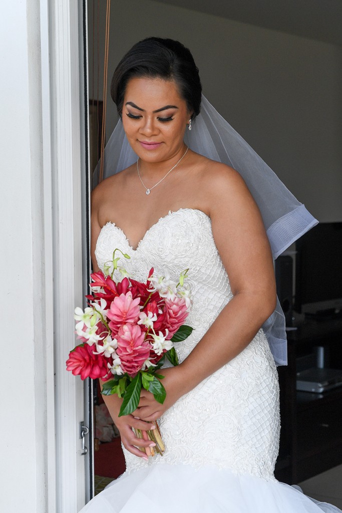 The stunning bride at the doorway with a pink and white ginger and frangipani flower bouquet