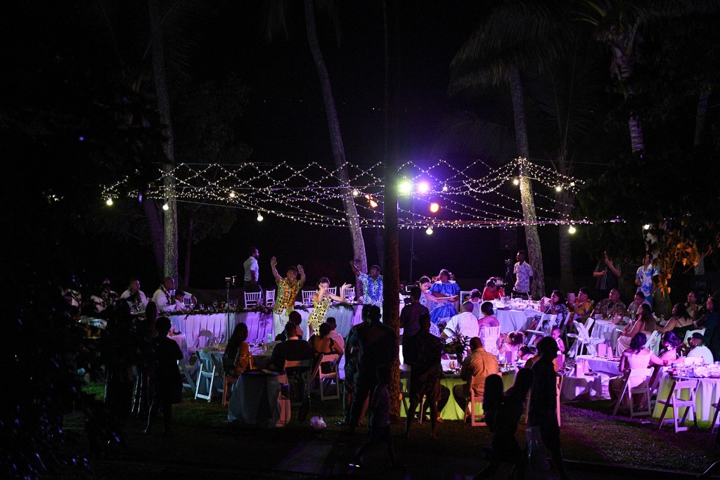 The wedding guests dance under fairy lights in the Fiji night sky