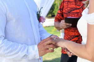 The grooms slips the ring on his bride's finger