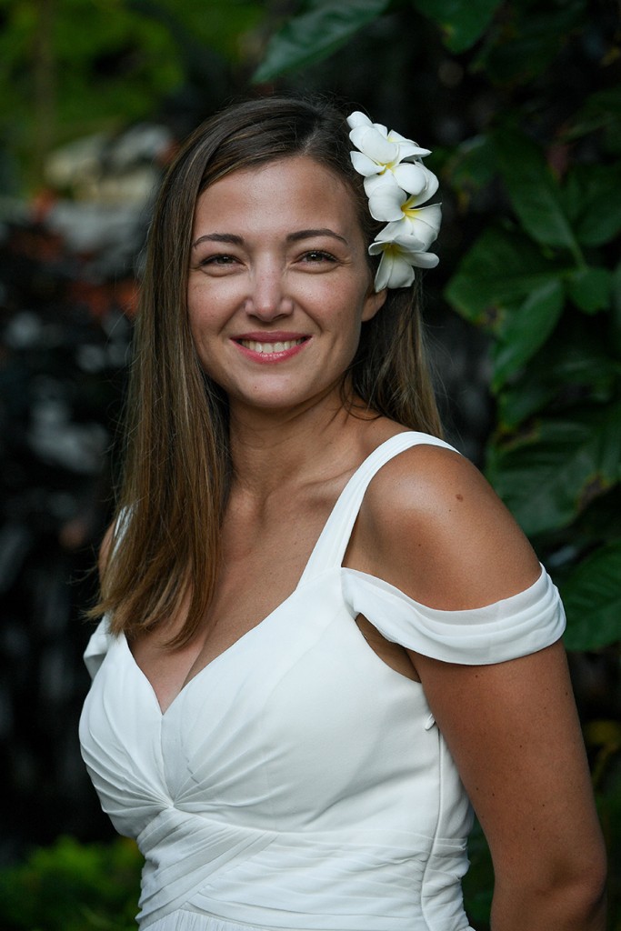 A portrait of the stunning bride with a white frangipani flower tucked in her hair