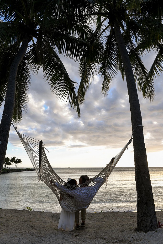 The loving couple enjoy the Fiji sunset swinging on a hammock