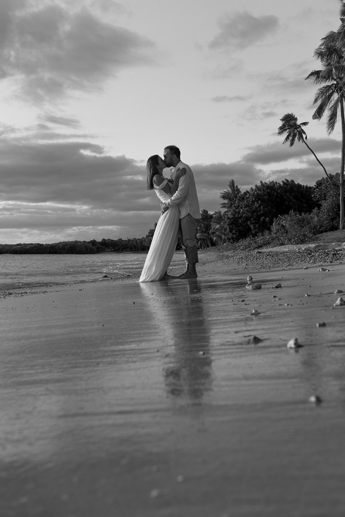 A monochrome image of the loving couple kissing in the sunset